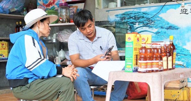 Hướng dẫn chủ cơ sở nước mắm Diệu Thủy xây dựng quy trình truy xuất nguồn gốc cho sản phẩm bằng tem truy xuất có mã QR. Ảnh: HH